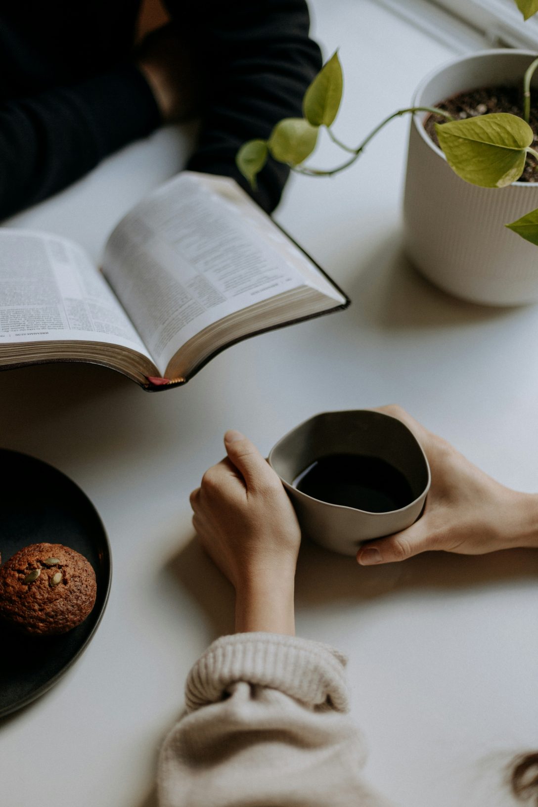 Man reading Bible, woman drinking coffee